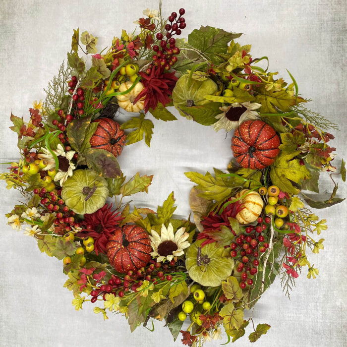Large autumn wreath with pumpkin patch decor and autumn leaves and sunflowers for the front door
