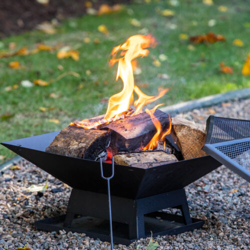 black firepit with log fire burning on a stone base