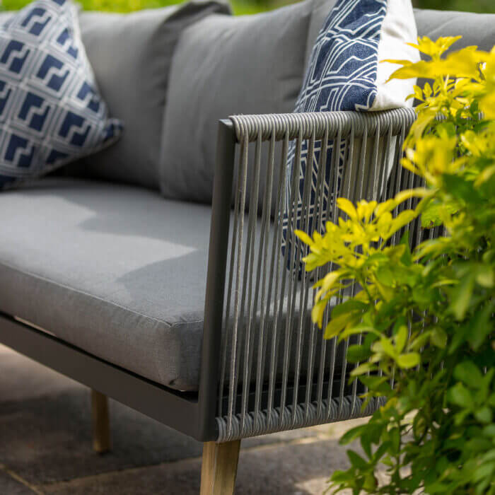 Newcastle Corner Sofa and Coffee Table with aluminium frame, rattan arm chairs and wooden coffee table in grey with shower proof cushions to lounge in the garden or patio detail of the end of corner sofa